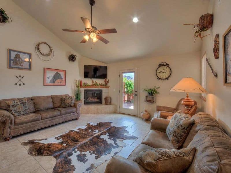 Living room with fireplace and cowhide rug at vrbo listing in Moab