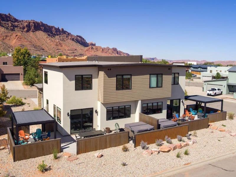 Exterior of modern twin home vrbo listing with outdoor seating and hot tub