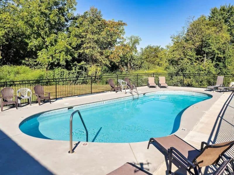 Community pool of Pigeon Forge vacation cabin, with lounge chairs and surrounding forest views.