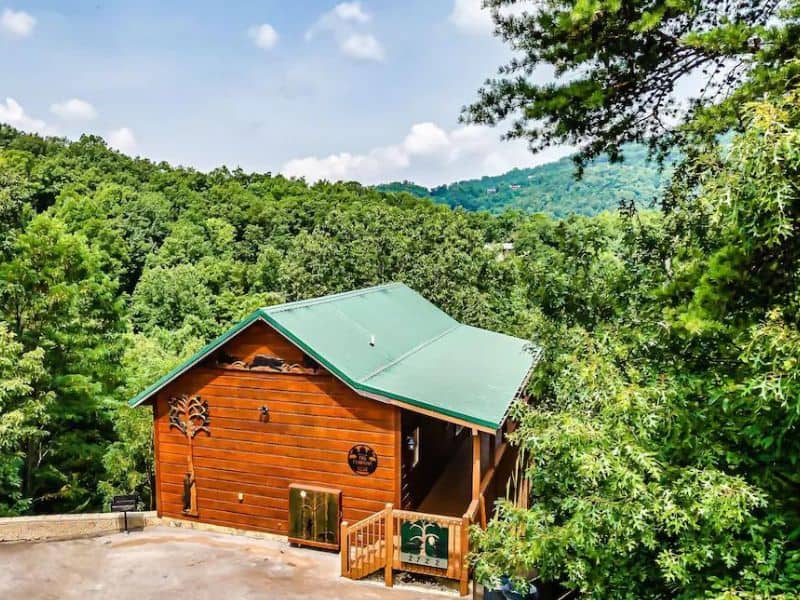 Exterior of wooden cabin in Pigeon Forge, overlooking green forest.