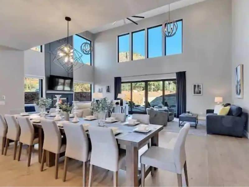 Large dining area and living room of Sedona home, with high ceilings, fireplace, and views of rock formations.