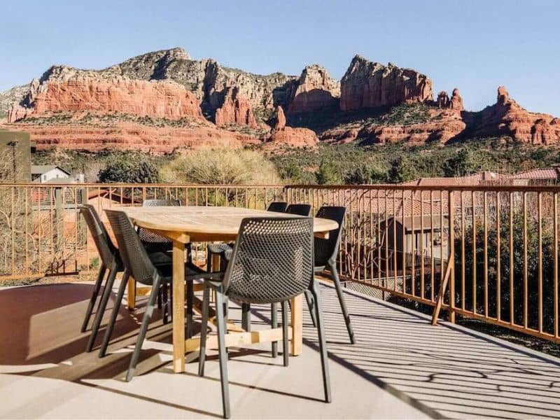Balcony dining area of Sedona rental property, with views of red rock formations.
