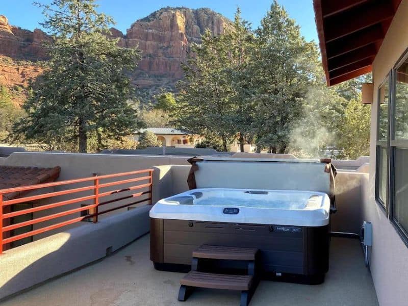 Balcony jacuzzi overlooking red rock formations of Sedona rental property.