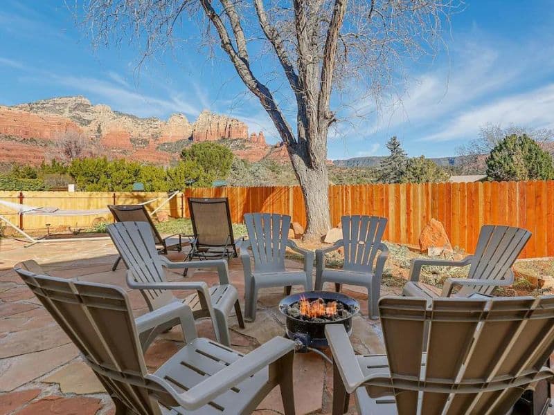Backyard fire pit with seating, with views of red rock formations of Sedona vacation rental.