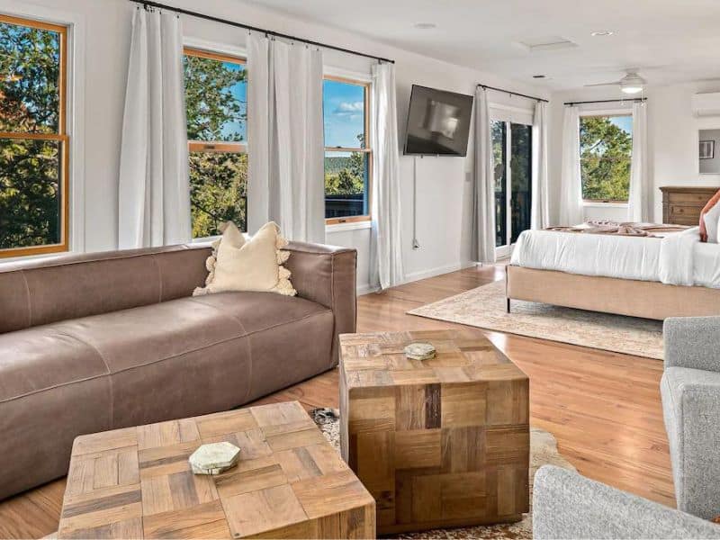 Master bedroom in Sedona airbnb, with living area and views of red rock formations.