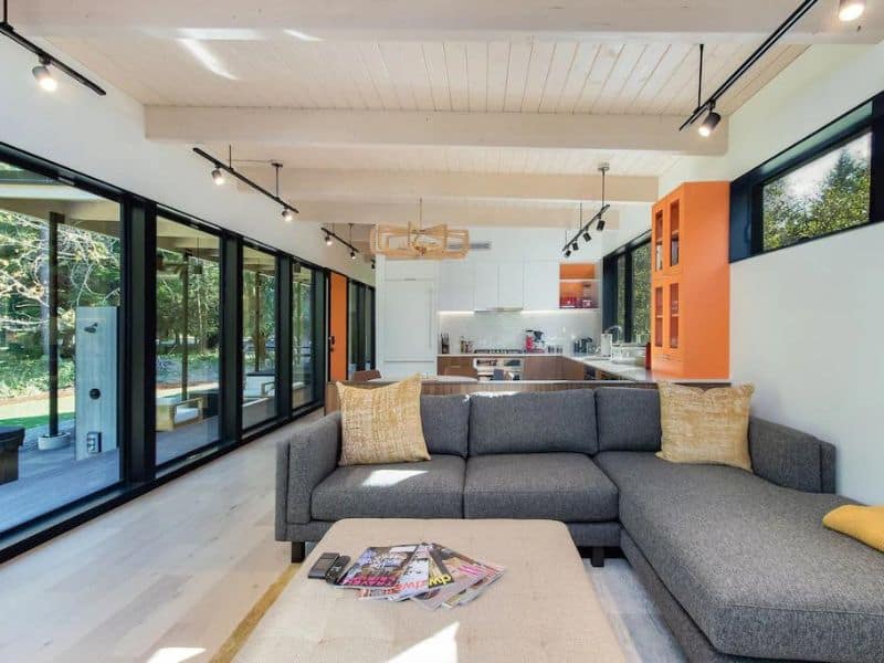 Modern interior of cabin rental near Mount Rainier with pops of color and large L-shaped couch