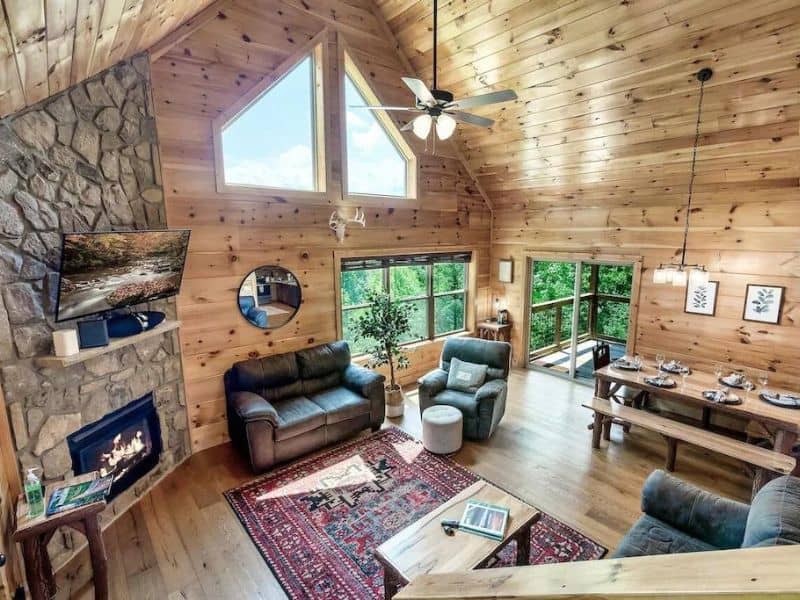 Rustic modern living area with fireplace and vaulted ceilings in pet-friendly cabin near Gatlinburg