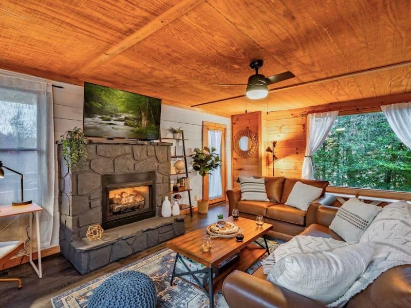 Living room with fireplace in pet-friendly cabin rental in Gatlinburg TN with leather couches and cozy blankets