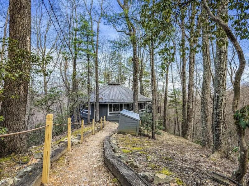 Path leading to circular grey cabin in Chalet Village - part of a guide to the best pet-friendly cabins in Gatlinburg, TN