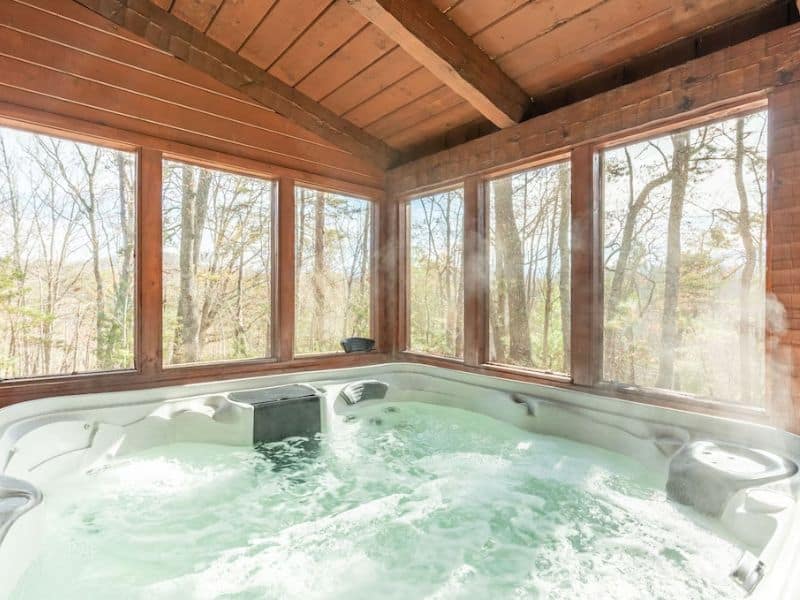 Covered hot tub in screen-in porch at cabin rental near Gatlinburg TN