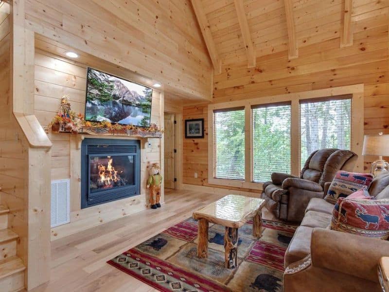 Living room with fireplace and TV in wood cabin rental in Gatlinburg