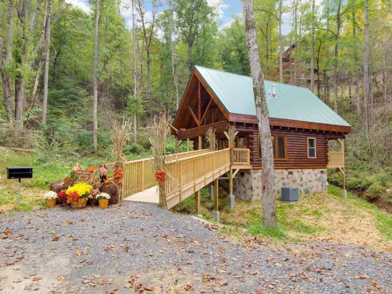 Small wood cabin with elevated wood walkway leading to the front entrance - part of a guide on the best pet friendly cabins in Gatlinburg TN