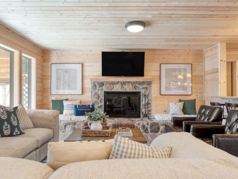 Cozy chic living room with stone fireplace, TV, and comfy couches in Gatlinburg pet-friendly cabin rental