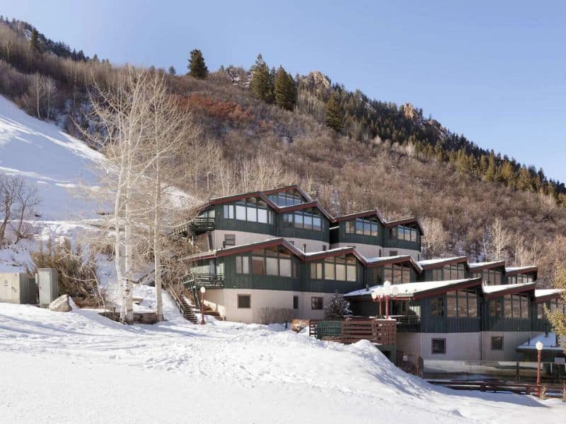 A ski lodge with a snowy slope in the background.