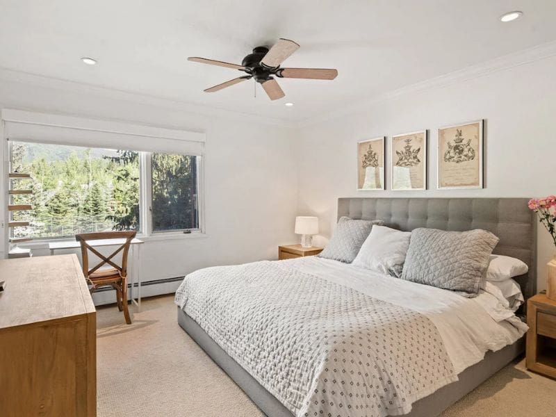 A bedroom with a ceiling fan and a bed located in a vacation rental in Aspen, CO with ski in ski out access.