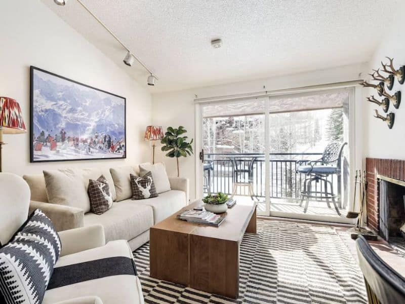 A living room with a fireplace and large windows in Aspen, CO.