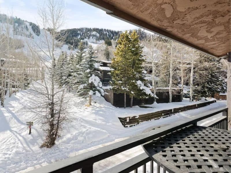 A balcony in Aspen, CO with a view of snow-covered mountains.