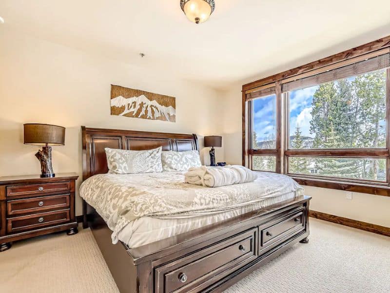 A spacious bedroom in a Breckenridge vacation rental with a large bed and an expansive window.