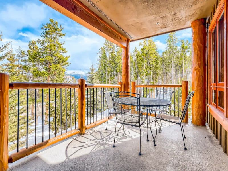 A balcony with a table and chairs overlooking the mountains in Breckenridge CO.