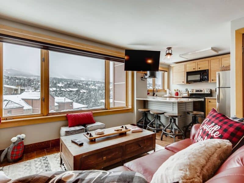 A cozy living room in a ski in ski out studio penthouse in Breckenridge with a small kitchen and beautiful views.