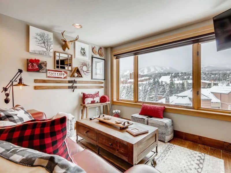 A cozy living room in a studio penthouse in Breckenridge with snowy mountain views from the window.
