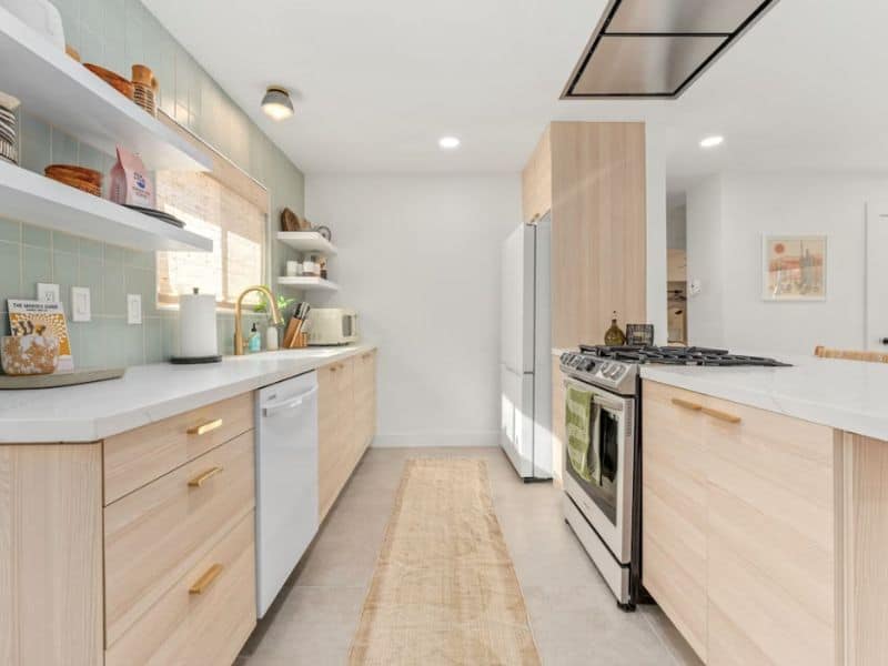 Bright modern kitchen with white cabinets and light wood cabinetry.