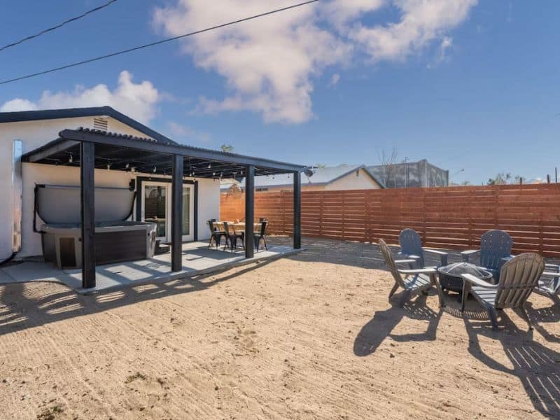 Joshua Tree vacation rental - backyard with a hot tub, patio, chairs, and fire pit.