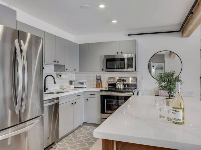 A kitchen with stainless steel appliances and a refrigerator.