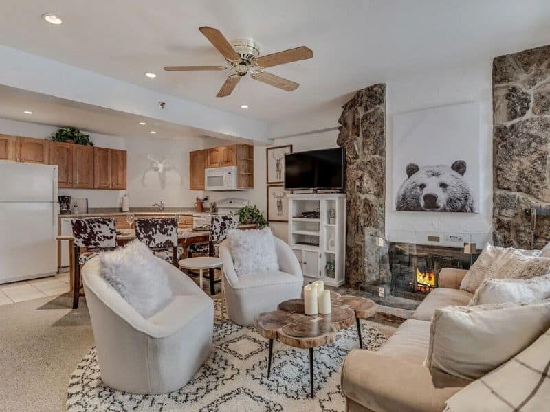 A living room with a fireplace and a flat screen tv at an Aspen CO ski in ski out vacation rental.