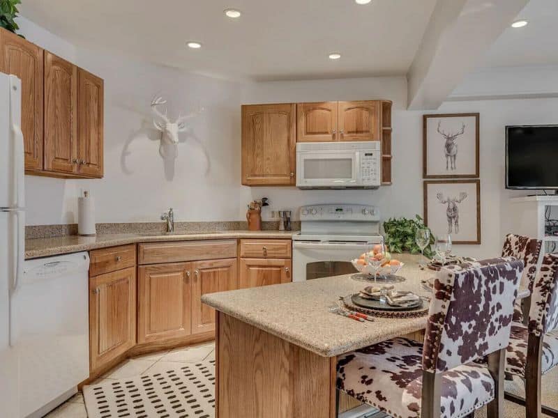 A kitchen with wood cabinets and a microwave.