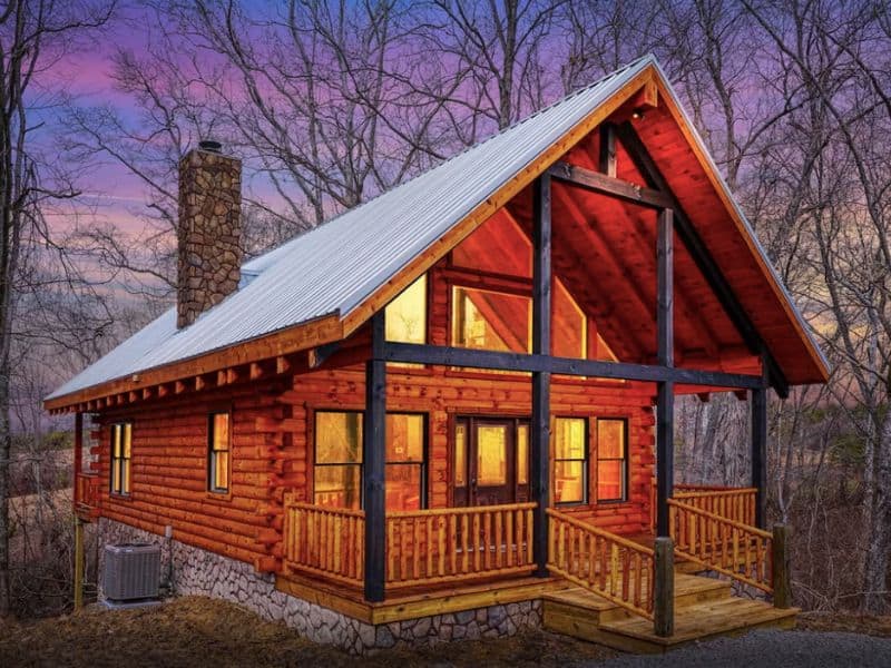 A luxury log cabin in Hocking Hills, OH with a covered front porch and vaulted ceiling.