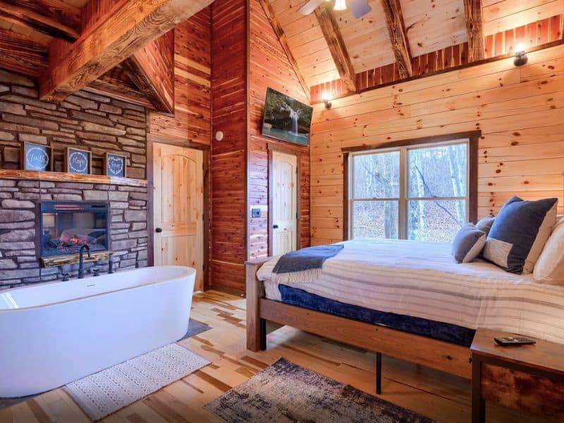 Master suite in one bedroom cabin in Hocking Hills on Vrbo with free standing tub and in-room fireplace.