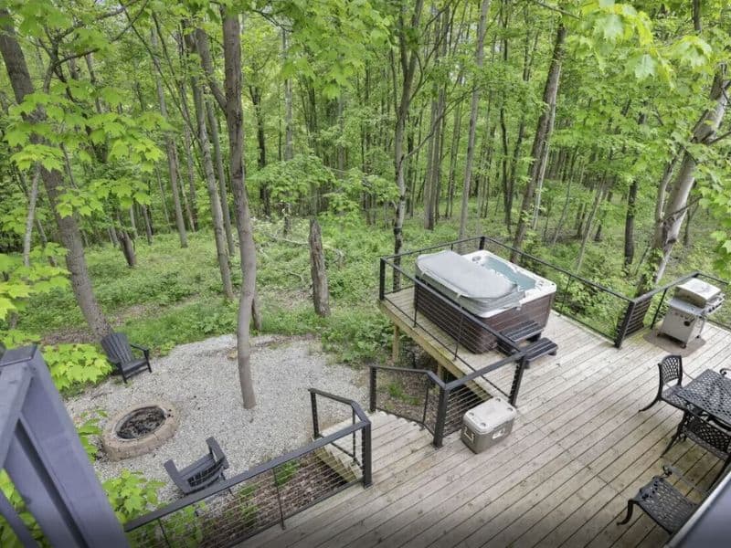 Hot tub on a wooden deck surrounded by woodland in Hocking Hills, OH.
