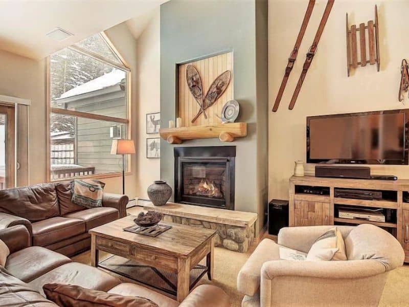 A cozy living room in Breckenridge CO ski in ski out vacation rental with a fireplace and decorative skis.