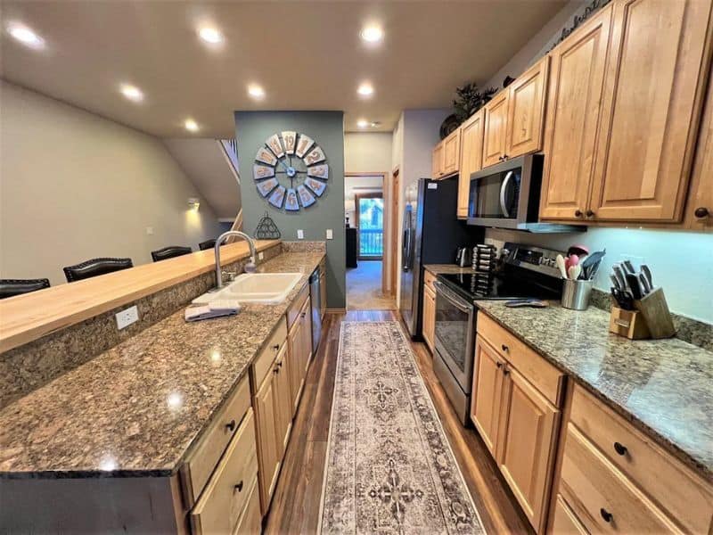 A kitchen with granite counter tops and stainless steel appliances.