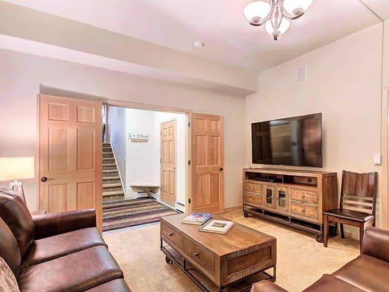 A living room with leather furniture and a TV.