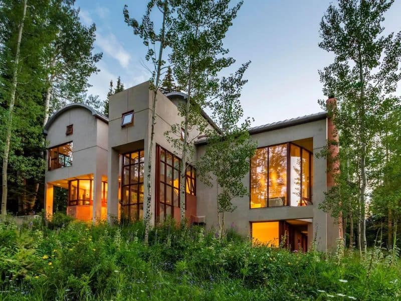 A modern home sits on top of a hill in the woods near Snowmass, Aspen.