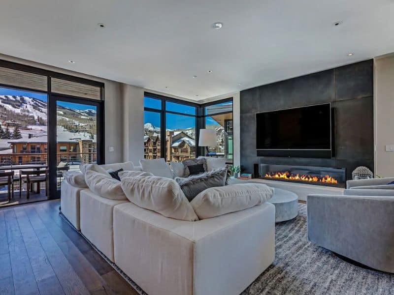 A modern living room with a fireplace and a view of the mountains in Snowmass, Aspen.