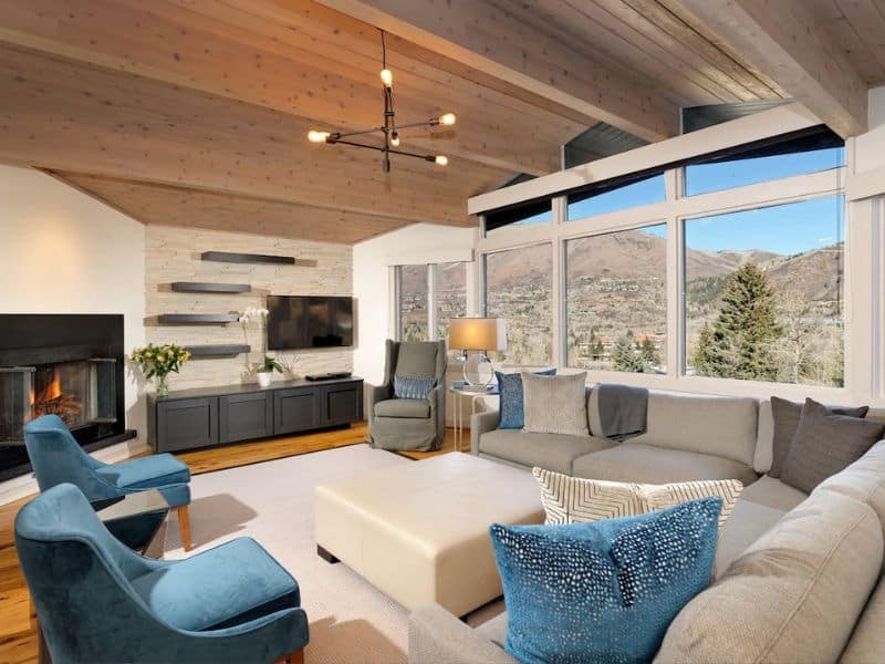 A contemporary living room with a fireplace and mountain views in Aspen CO.