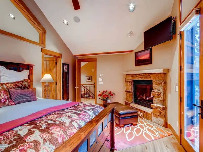 A large bedroom in with a fireplace in a luxury Breckenridge vrbo rental.