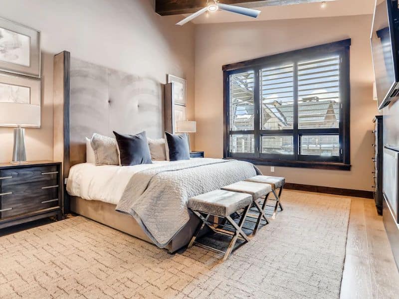 A large modern bedroom with a king-sized bed and a ceiling fan.