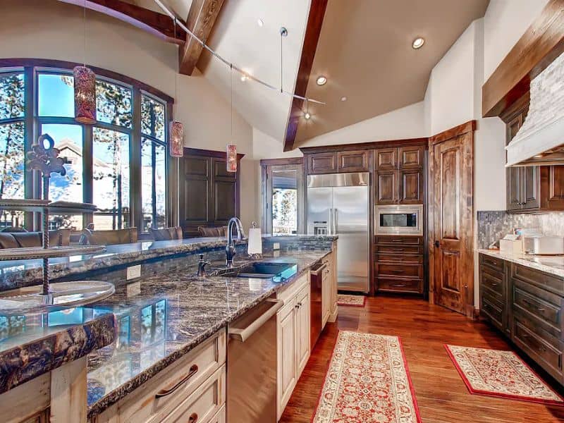 A large kitchen with granite counter tops and wooden cabinets.