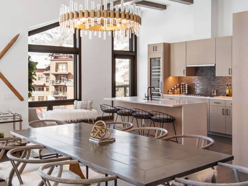 A modern kitchen with a dining table and chairs in a Snowmass penthouse rental.
