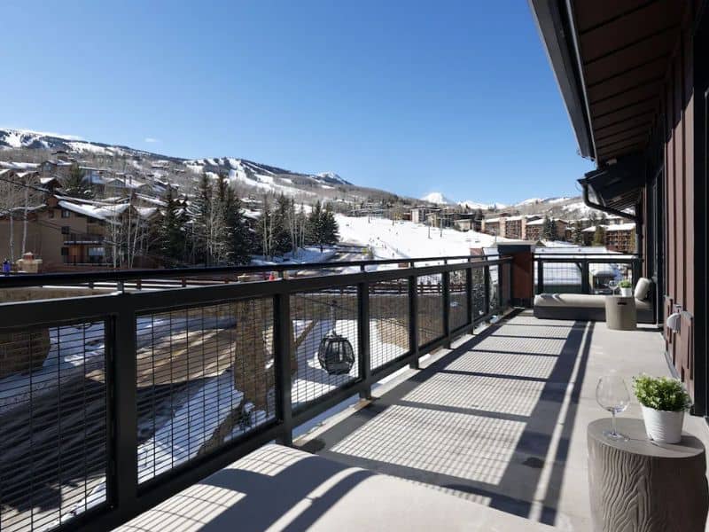 A balcony with a view of the mountains and snow in Snowmass Village CO.