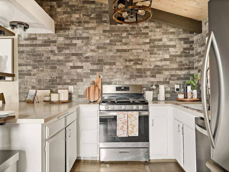 Modern kitchen with stone backsplash and stainless steel appliances in a Big Bear cabin near Snow Summit.