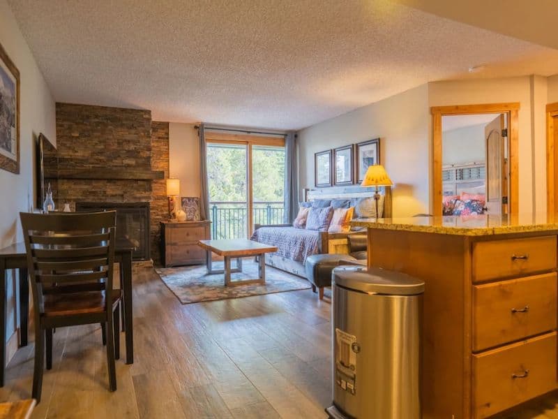 A cozy living room, kitchen and dining area in a Breckenridge ski in ski out condo rental.