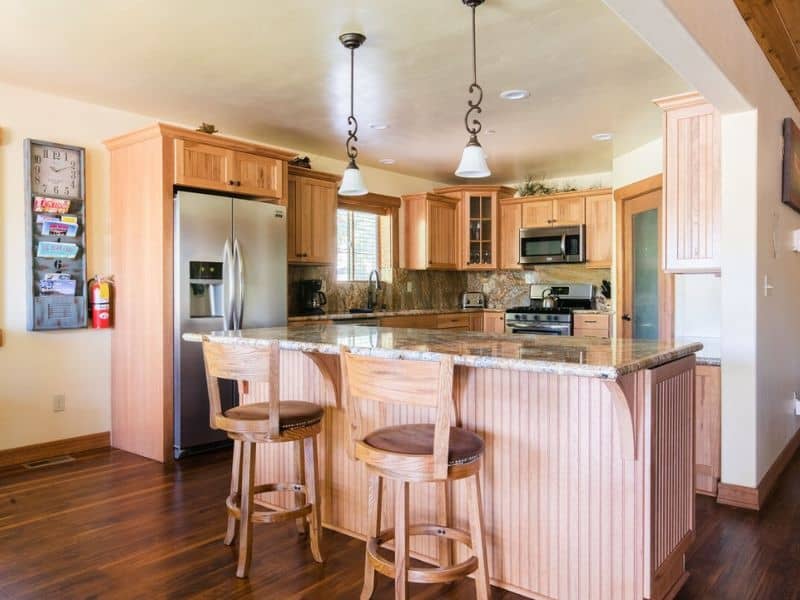 A kitchen in Big Bear CA with wood floors and bar stools.