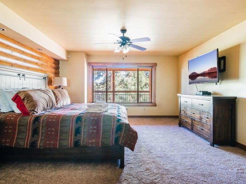 A spacious bedroom with a king-sized bed and a flat screen TV, located in Big Bear CA.