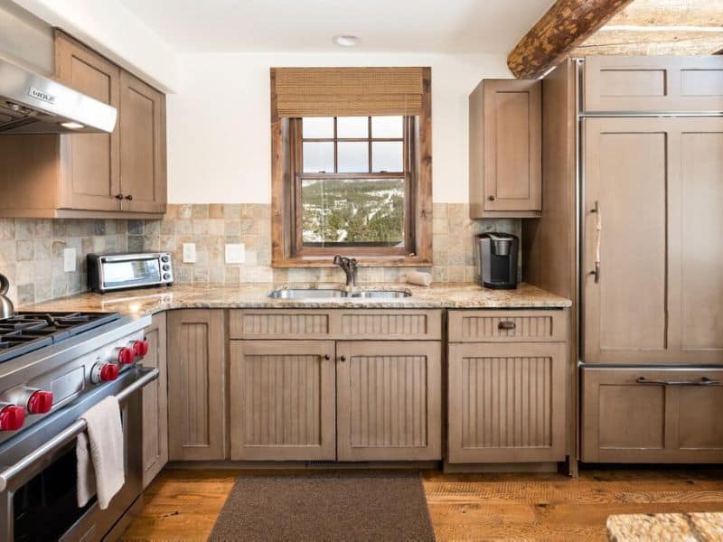 Fully-equipped kitchen with stainless steel appliances and wooden cabinets in a ski in ski out Big Sky MT rental.