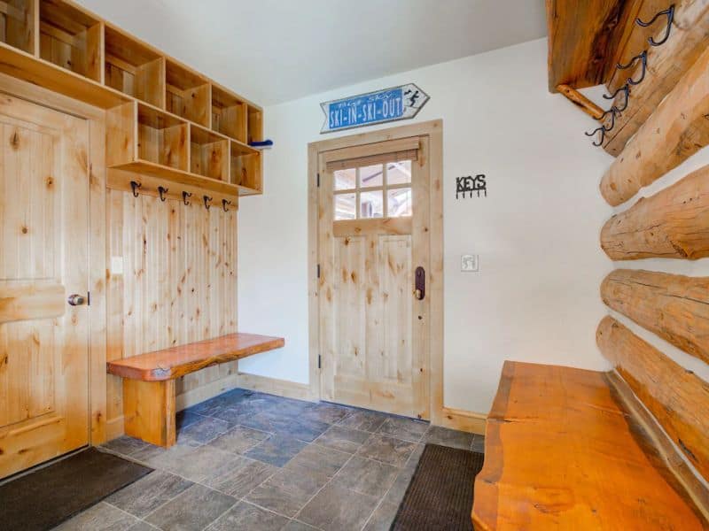 Mudroom with wooden benches and storage, a convenient feature of a Big Sky ski in ski out rental.